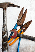 Hammer, Blechschneider und Schraubenschlüssel auf Metall