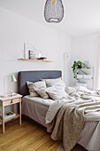 Bed with grey, upholstered headboard in bedroom