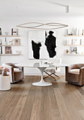 Sessel um Designertisch vor Wand mit Gemälde und Bilderleisten