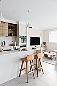 Modern interior decorated in white and beige with open-plan kitchen area