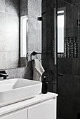 Modernes Bad in Schwarz und Weiß mit Waschbecken und Dusche