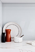 Carafe, mortar and pestle, and plate on marble worksurface