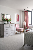 Chest of drawers with vintage chair and pendant at window