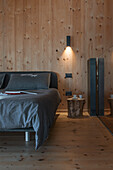 Doppelbett im Schlafzimmer mit Holzverkleidung