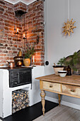 Wood-burning stove and exposed brick wall with candles in corner of room