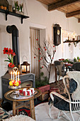 A cosy sitting area with a side table decorated for Christmas in front of a fireplace
