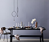 Modern gedeckter Esstisch mit Orchidee und minimalistischer Pendelleuchte