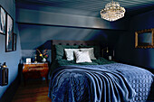 Bedroom all in blue with antique decoration and sloping roof