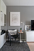 Polsterstuhl vorm Spiegelschrank im Wohnzimmer in Grau und Weiß
