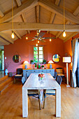 Dining room table with colorful walls and wooden ceiling with exposed beams
