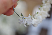 Thread white lilac flowers for a wreath on a wire
