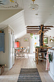 Offener Wohnraum mit Holzdielenboden und weiß gestrichener Holzdecke