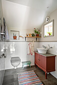 Red washstand with countertop basin and toilet in bathroom
