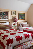Quilts with maple leaf pattern on twin beds in rustic guest room