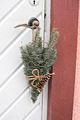 Spruce branches in chicken wire bags as door decoration