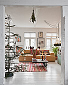 View into the living room with Christmas tree and yellow sofa