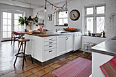 Offene, weiß getünchte Küche mit Terrakottafliesenboden