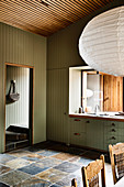 Grüne Holzverkleidung und Fliesenboden in Einbauküche mit Fenster