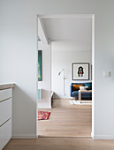 Durchgang zum Wohnzimmer mit blauer Couch, Wandleuchte und Bild an der Wand