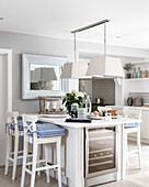 Breakfast bar with white bar stools and chambray seat pads