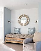Buttoned daybed in cosy corner with small pewter wall lights, the armchair is upholstered