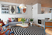Bright seating area in an open living room with black and white striped carpet