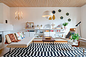 Retro Sitzmöbel au schwarz-weiß gestreiftem Teppich in hellem Wohnzimmer