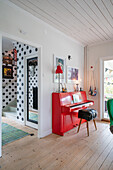 Rotes Klavier im Wohnzimmer, Flur mit gepunkteter Tapete