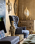 Sessel und asiatische Vase im Wohnzimmer mit goldenen Wänden
