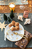 Christmas table setting with gold colored cutlery and pastries