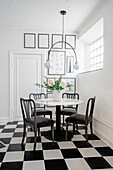 Small dining area in a kitchen with a retro black and white tiled floor