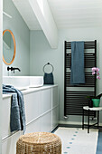 Vanity furniture with two countertop basins and black towel dryer in the bathroom