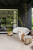Rattan sofa, plant, and tree trunk stool on the terrace