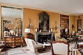Large Georgian portrait above marble fireplace in drawing room with wall sconces and French chest of drawers