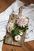 Dahlias and ornamental squash on wooden board