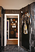 Kimono hängt an dunkler Marmorfliesenwand im Badezimmer, Blick auf Flur mit Dekoration