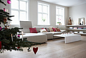 Christmas tree, pale sofa with scatter cushions and coffee table in living room