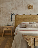 Doppelbett mit Naturteppich als Bettkopfende im Schlafzimmer mit sandfarbener Wand