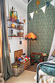 Play corner in the children's room with wallpaper and high ceiling