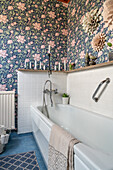 Badewanne im Badezimmer mit Blumentapete