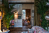 Salvaged 18th century French panelling with wide oak reclaimed floorboards underlit houseplants for theatrical effect