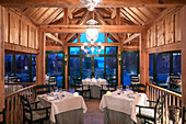 Gedeckter Tische im Restaurant mit Holzkonstruktion zur blauen Stunde