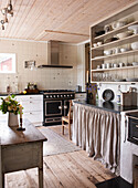 Geschirrregal über Arbeitsplatte aus Stein in Küche mit Holzdielenboden