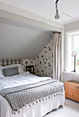 queen bed in the bedroom in grey tones in the attic