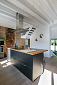 Moderne Kochinsel und Dunstabzugshaube in Loft mit Backsteinwand