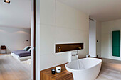 En-suite bathroom with bathtub and wooden shelf