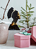 Vintage Engel aus Papier als Baumanhänger, darunter rosa Geschenkschachtel