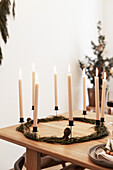Minimalistischer Kranz mit weißen Kerzen auf Esstisch