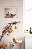 Wintery branch with DIY paper stars and candle lanterns on side table