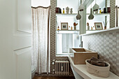 Washstand with stone countertop sink and beige wall tiles in bathroom with frosted-glass window